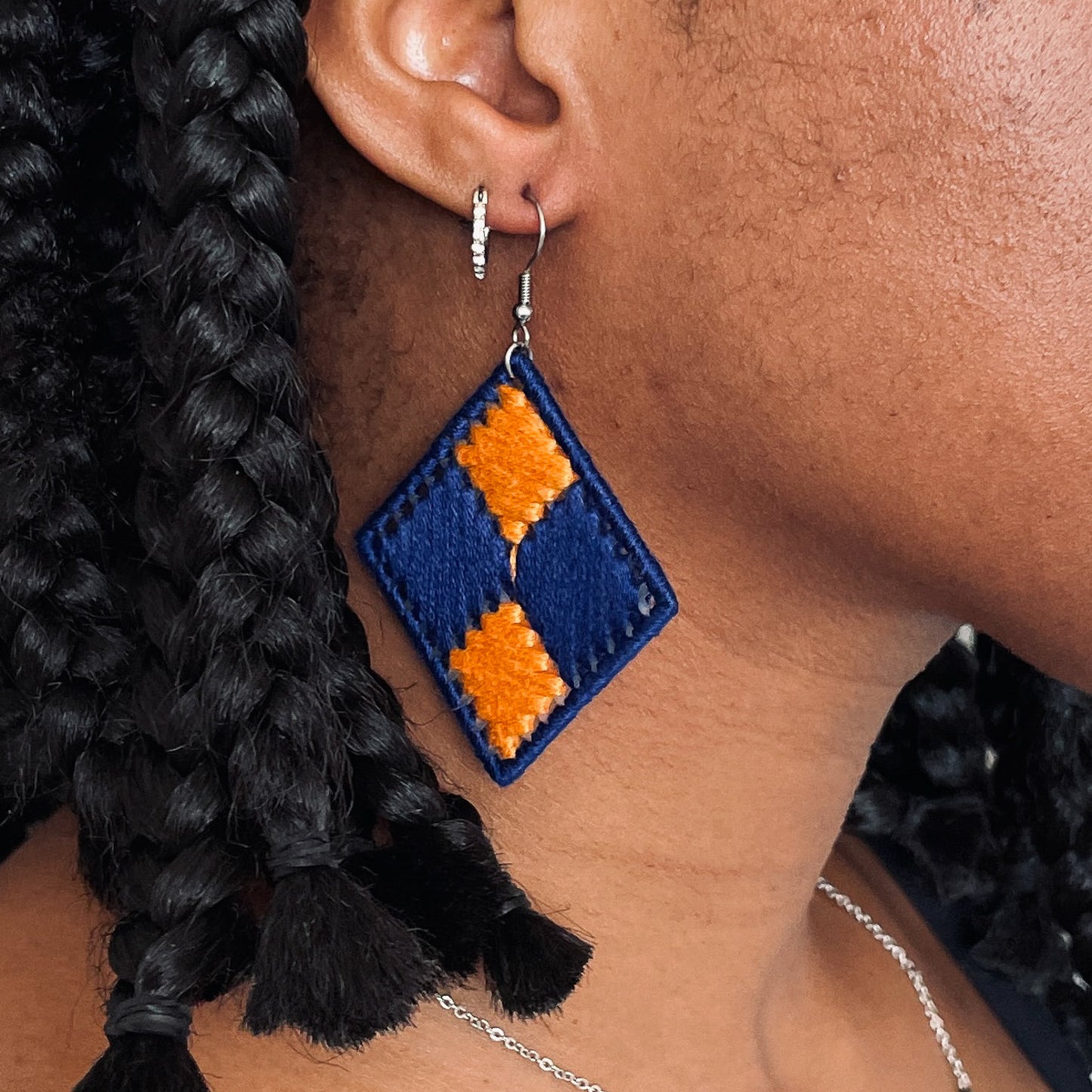 Model wearing the blue and yellow Benni earrings, styled with braided hair