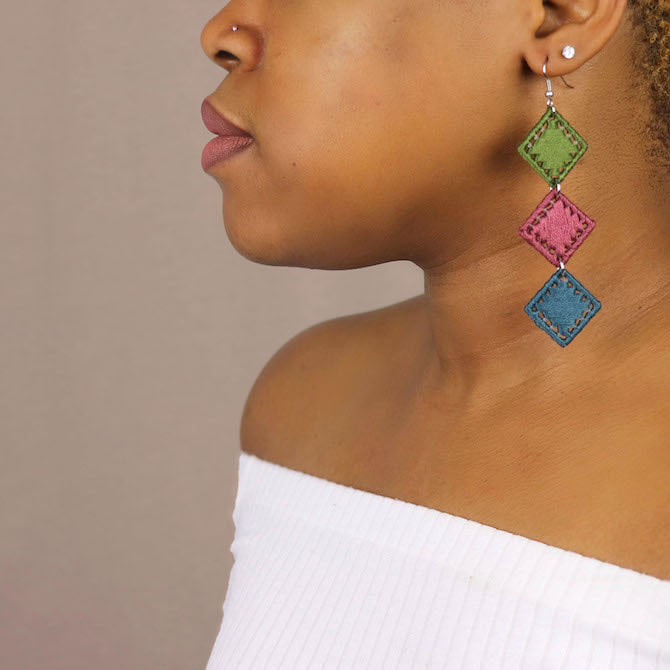 The Bunmi statement earrings in an alternate colorway, elegantly displayed against a neutral backdrop