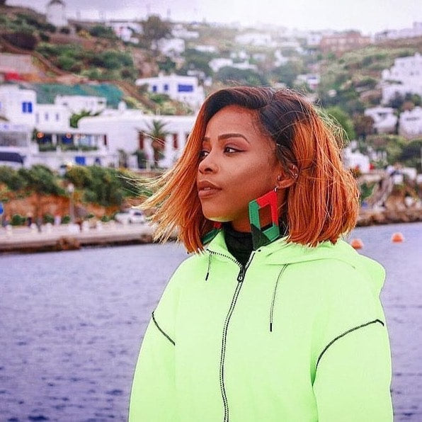 Styled look featuring The Joel earrings with a neon green jacket by the water