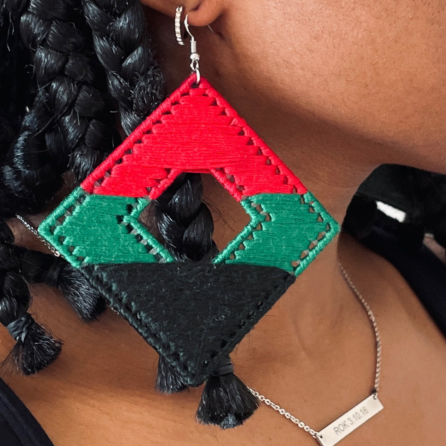Model wearing the Joel earrings in red, green, and black with braided hair
