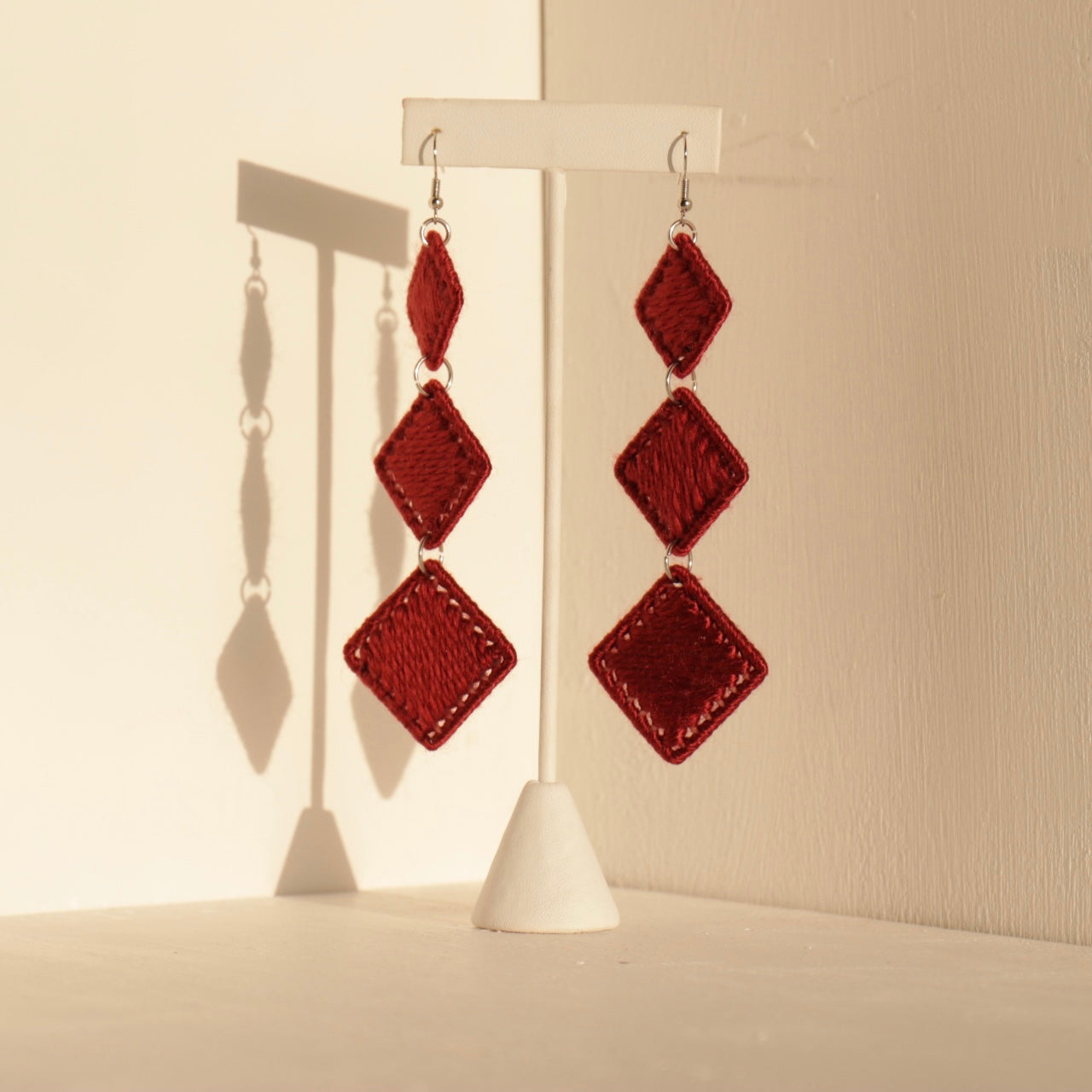 Deep red Kambi earrings, a striking blend of artistry and structure, perfect for effortless elegance.