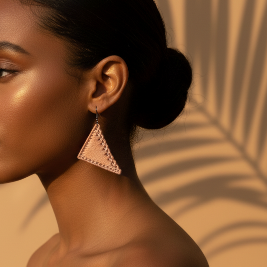 Woman with a bun and geometric earrings against a beige background