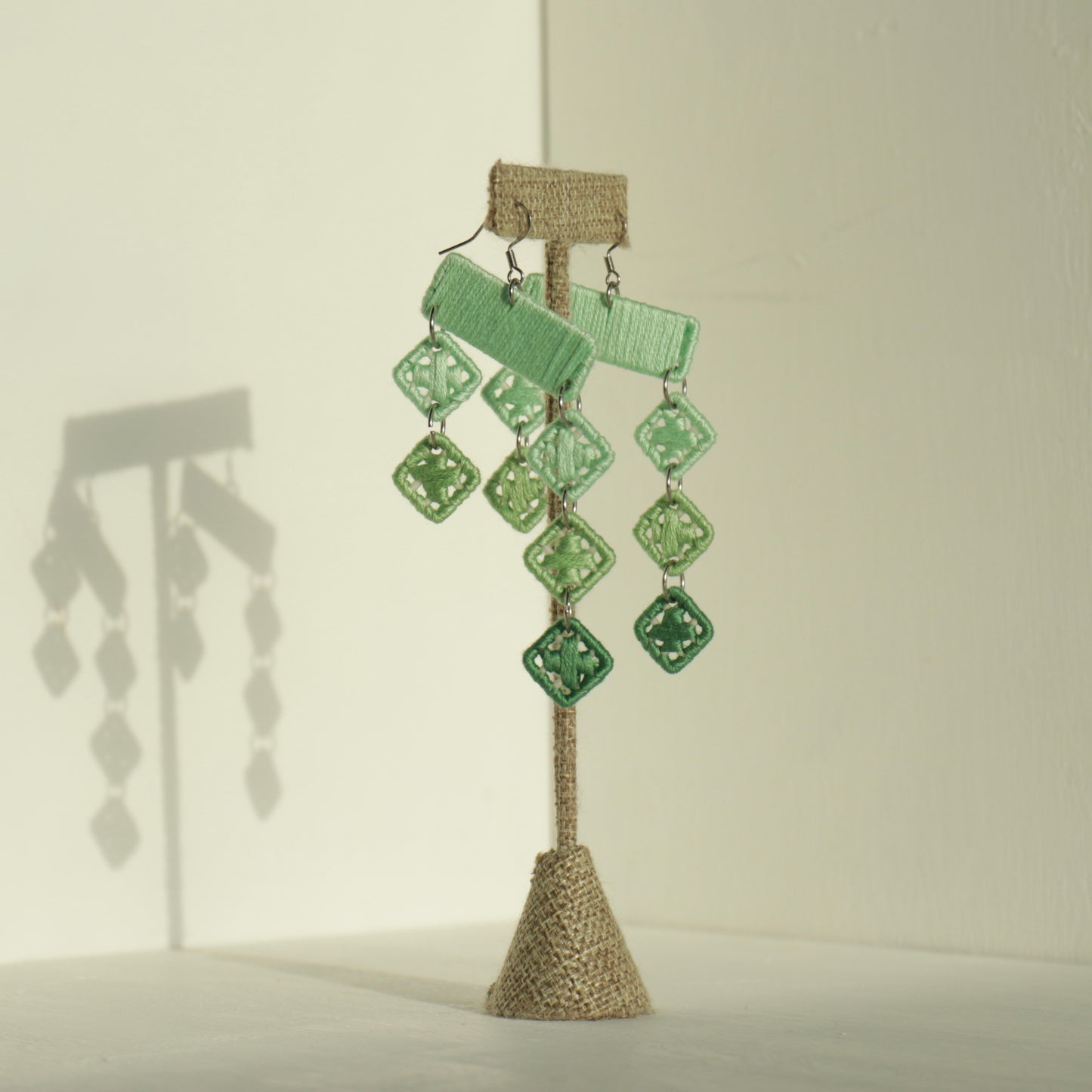 The Finesse earrings in green by OlaNti, featuring cascading geometric shapes with a dynamic flow. Handcrafted in Houston