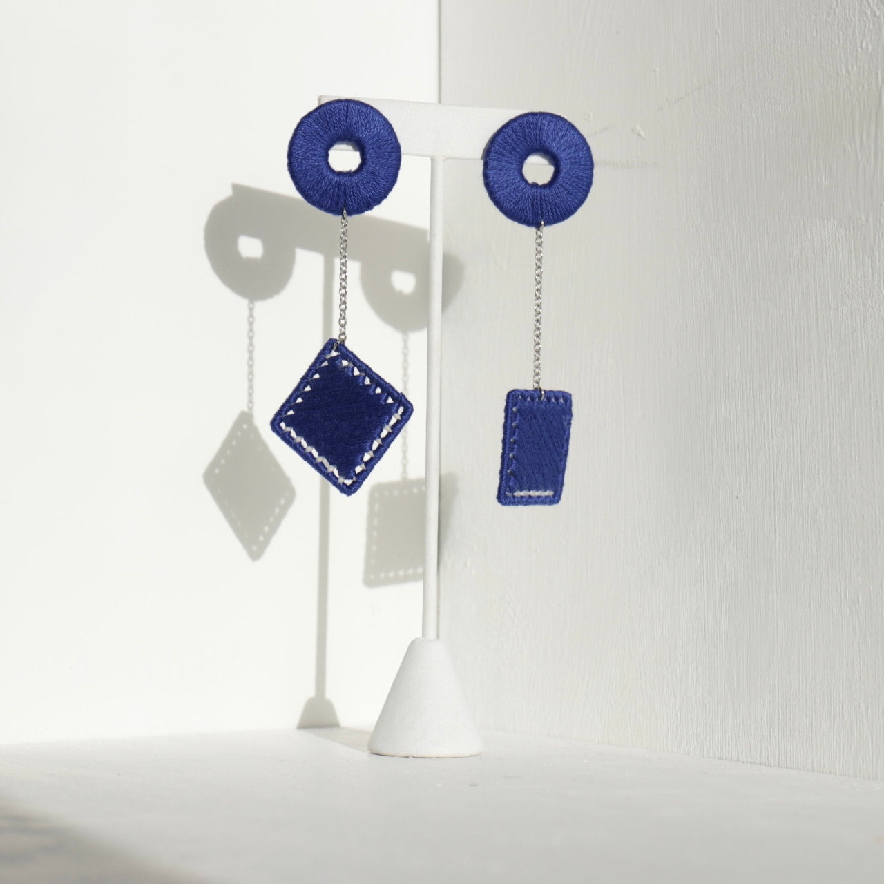 The Klowii earrings in blue by OlaNti Houston, featuring geometric circular and square elements