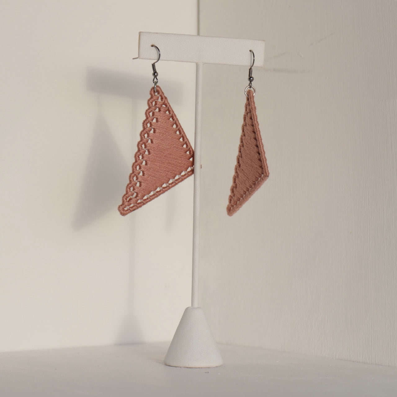 The Kofi earrings in blush by OlaNti Houston, featuring a sleek triangular silhouette
