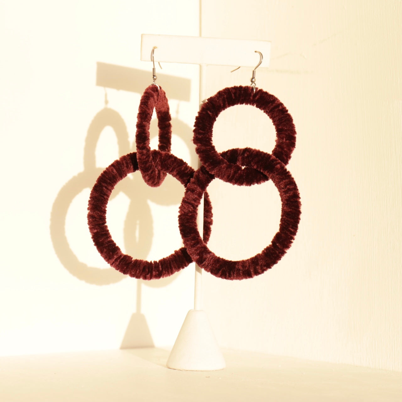 The Valente earrings in burgundy with an interlocked circular design