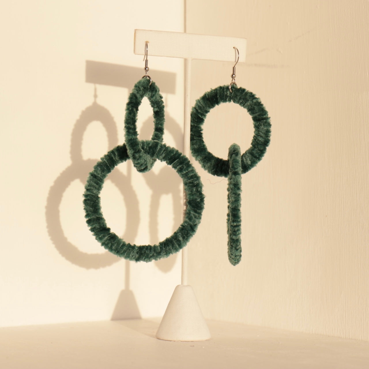 The Valente earrings in green, emphasizing their sculptural elegance