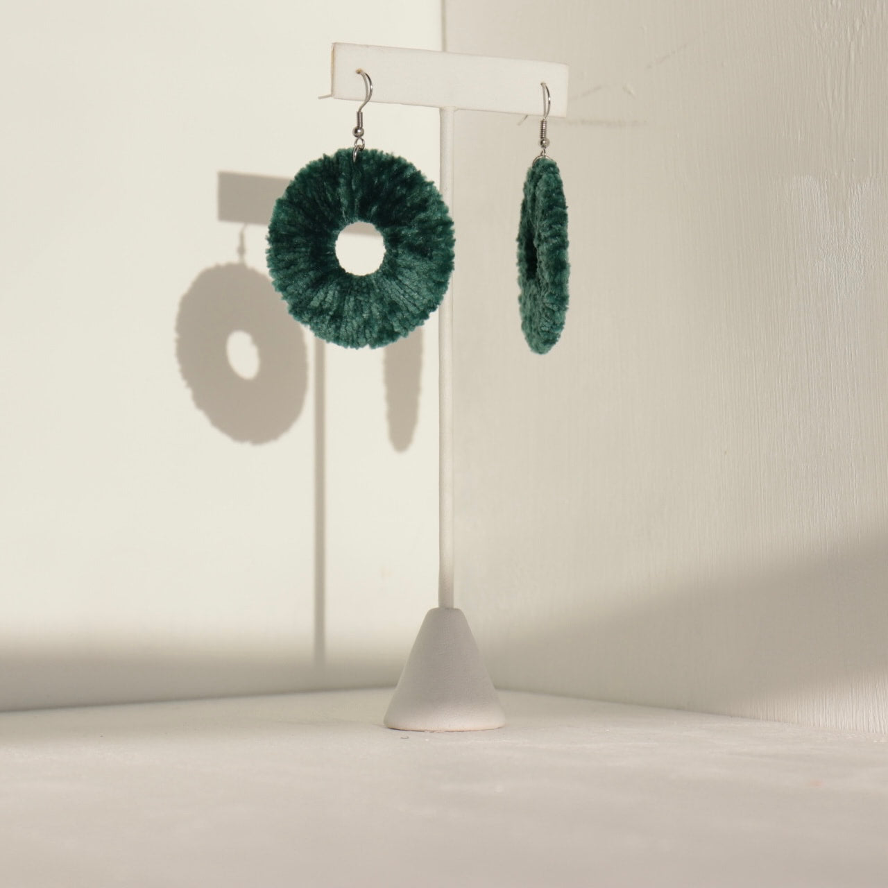 The Vinny earrings in deep forest green, capturing their lightweight yet sculptural form