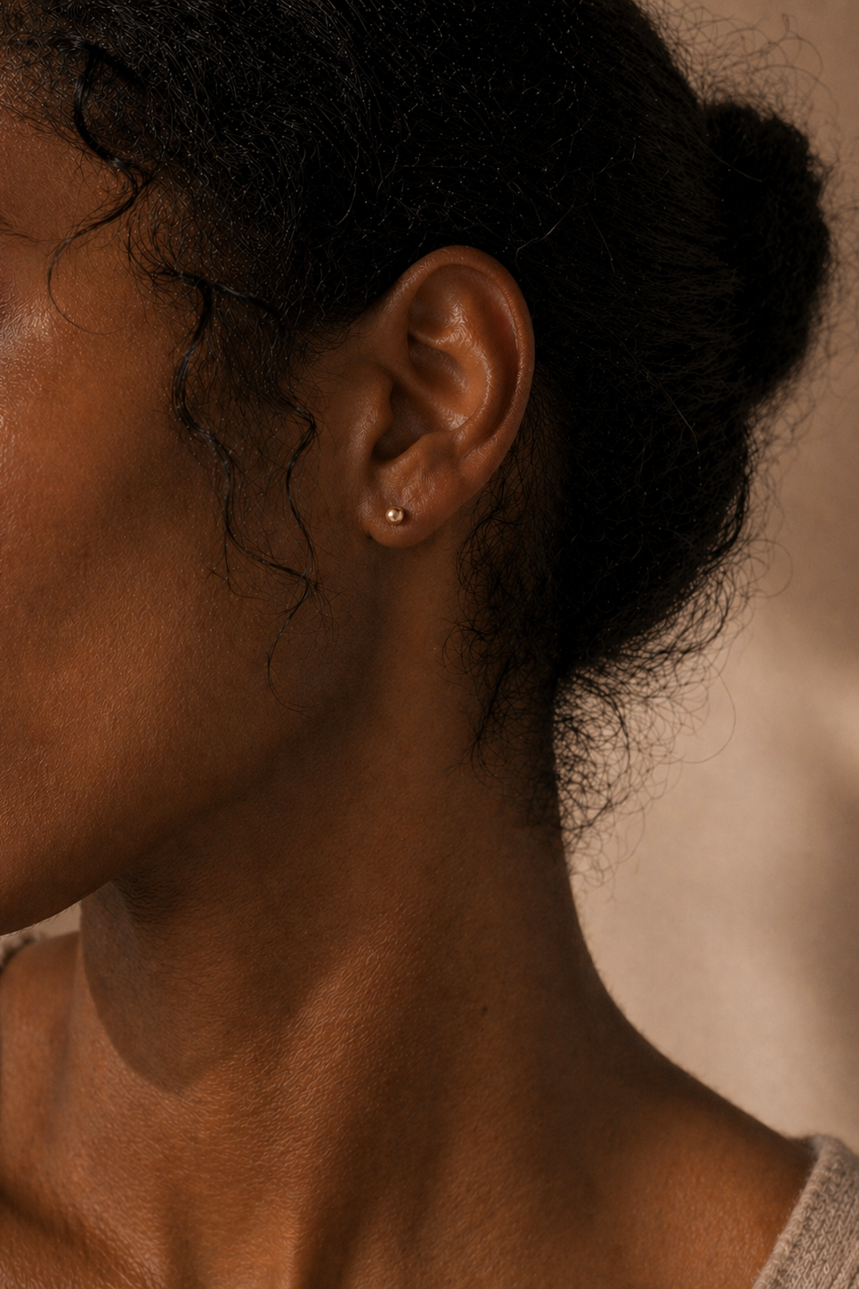 Woman wearing gold ball stud earrings