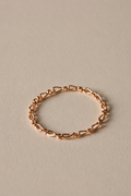 Rose gold chain ring on a beige background
