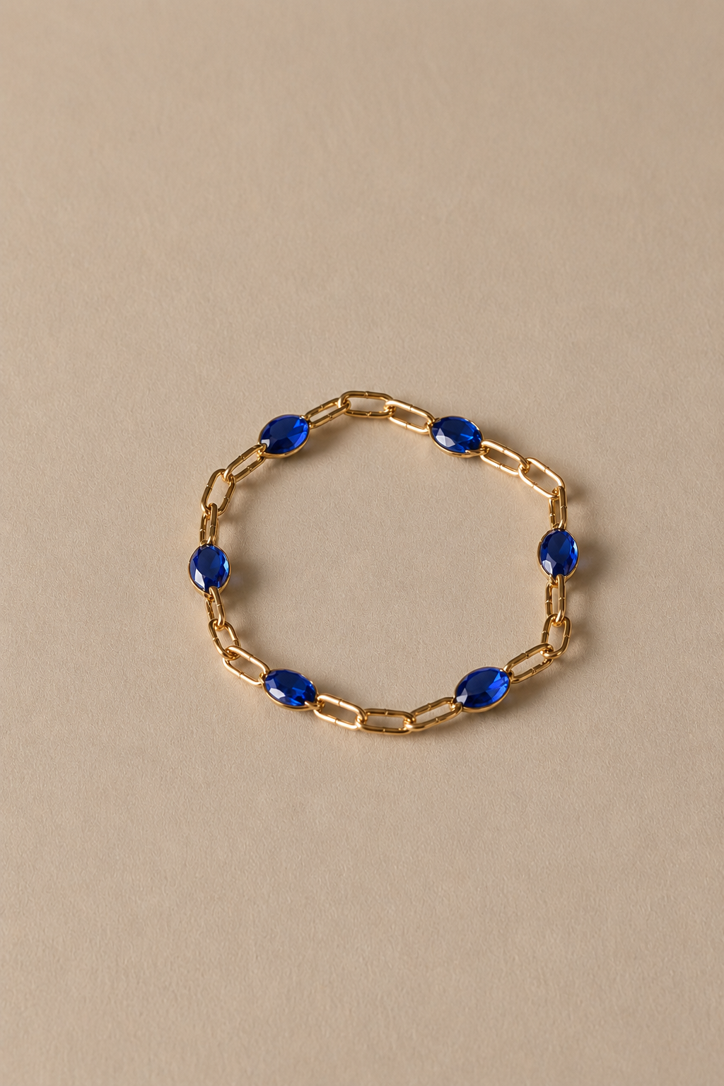 Blue gold chain ring on beige