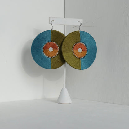 Close-up of the Damek Statement Earrings, featuring a bold geometric design with a balance of earthy green, deep blue, and warm orange hues. Handmade and lightweight.
