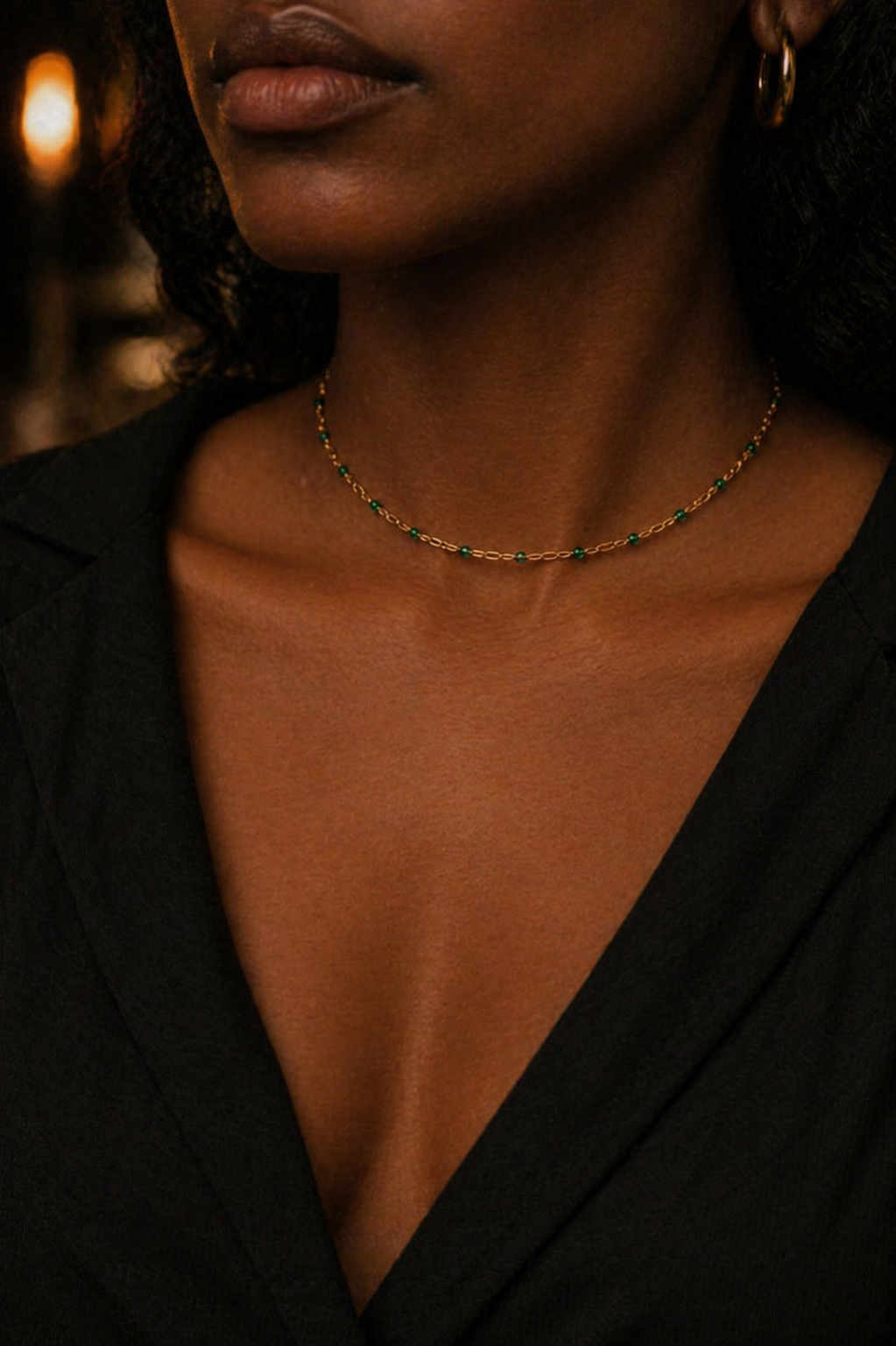 Close-up of a person wearing a delicate necklace with a blurred background