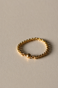Gold chain ring on a beige background
