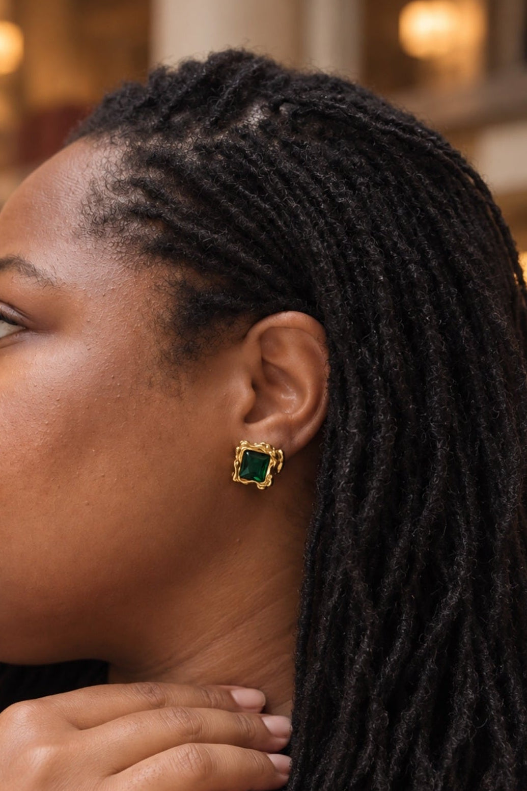 Woman wearing green stud earrings
