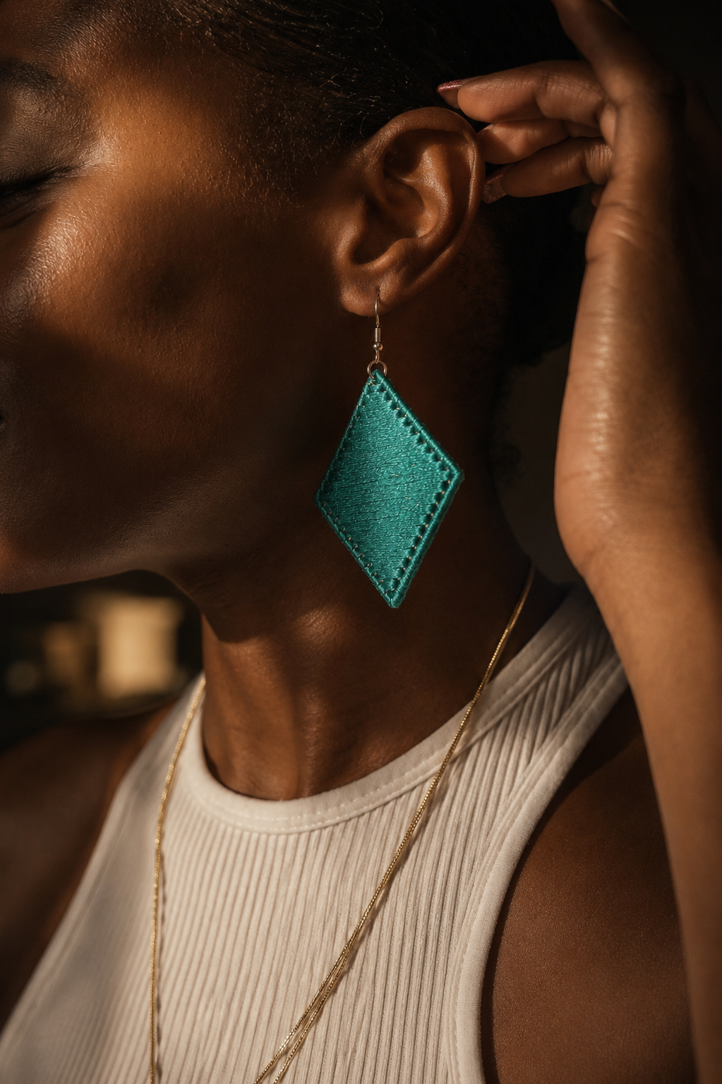 Close-up of a person wearing a turquoise earring with a blurred background