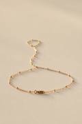 Gold Hand Chan bracelet on a beige background