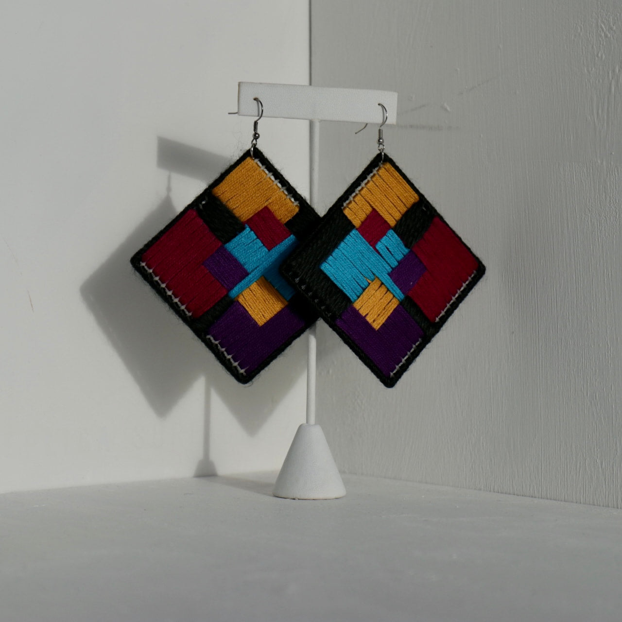 Geometric statement earrings featuring a handcrafted abstract design in vibrant colors. Made using needle art on a lightweight base for a bold yet comfortable wear