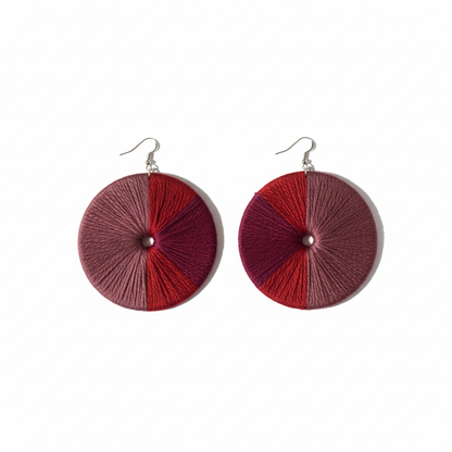 Pair of round earrings with red and pink gradient design on a white background