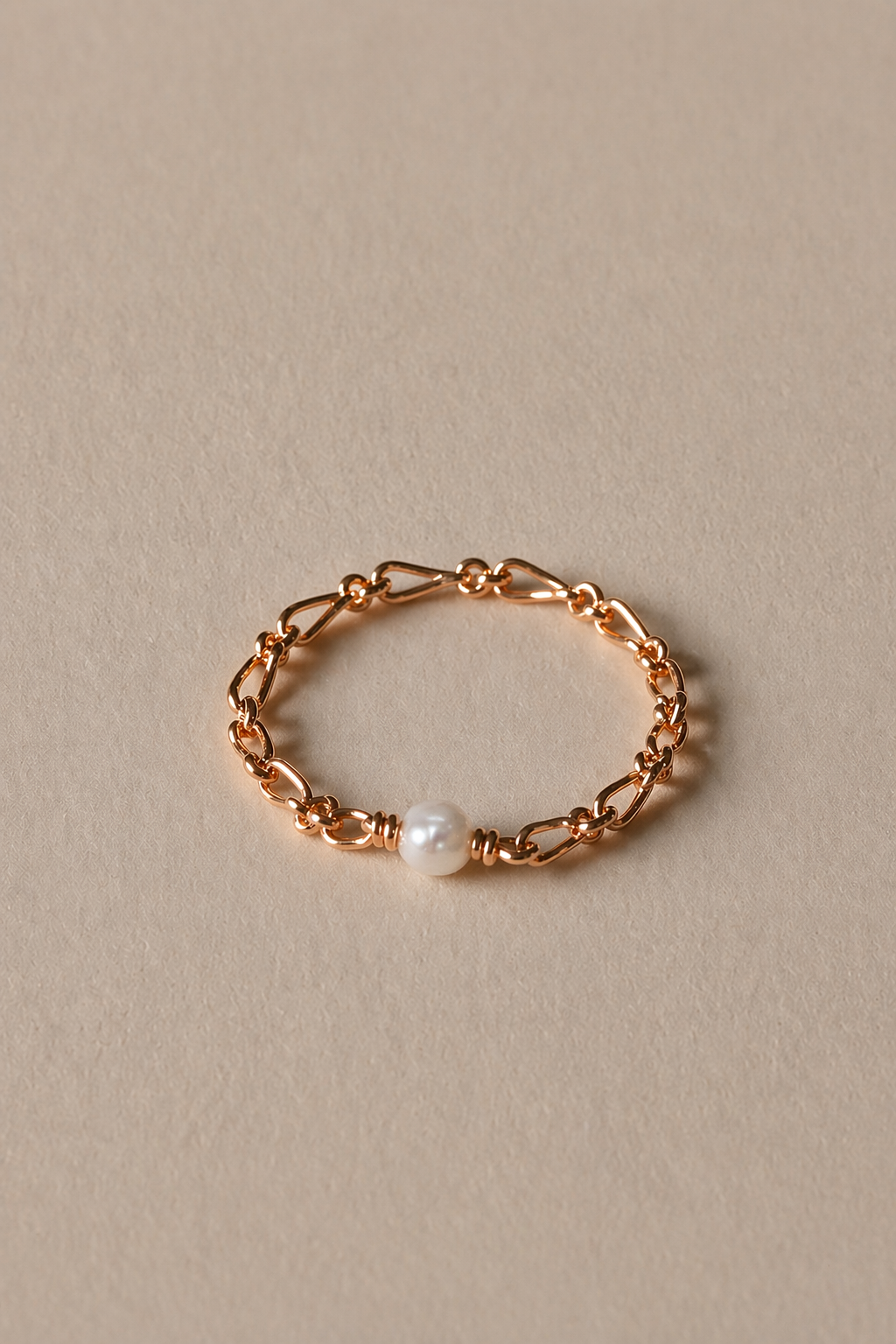 Gold ring with a pearl on a beige background