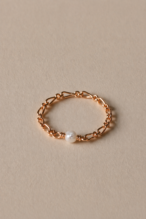 Gold ring with a pearl on a beige background