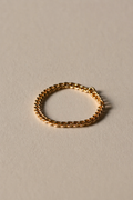 Gold chain ring on a beige background