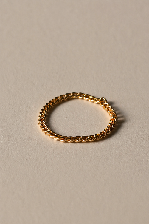 Gold chain ring on a beige background
