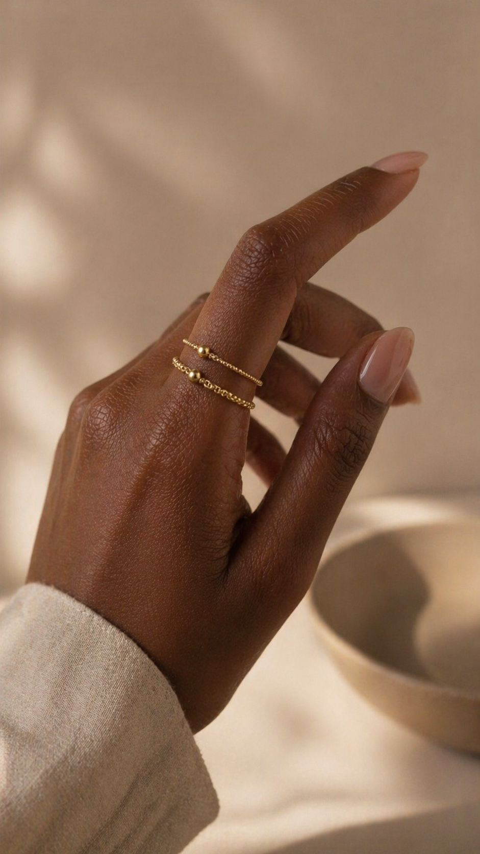 A woman wearing two gold chain rings
