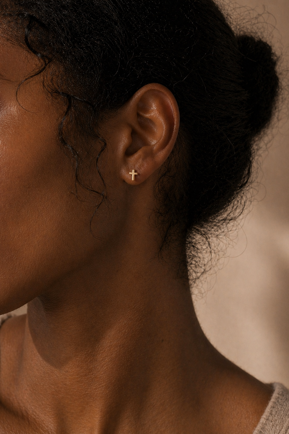 Woman wearing gold cross stud earrings
