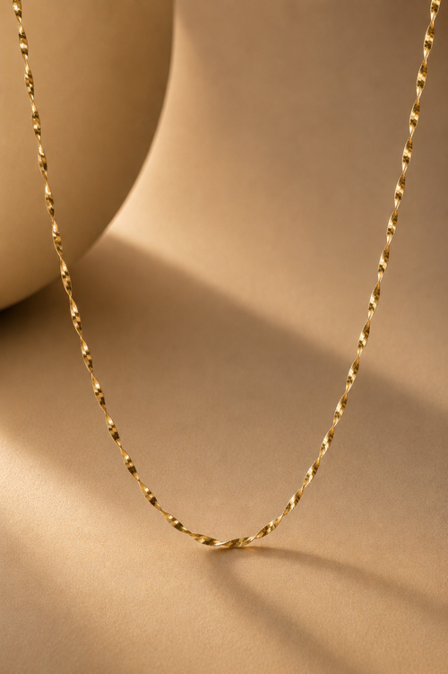 Gold chain necklace on a beige background