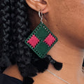 Close-up of a model wearing the green and pink Benni earrings, capturing the bold craftsmanship