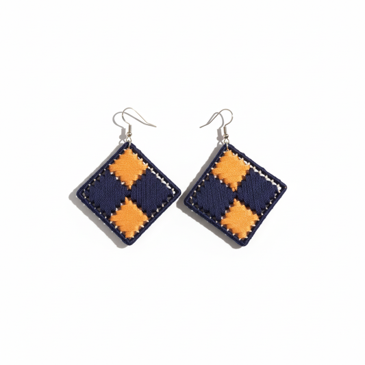 Pair of square earrings with orange and navy checkered pattern on a white background