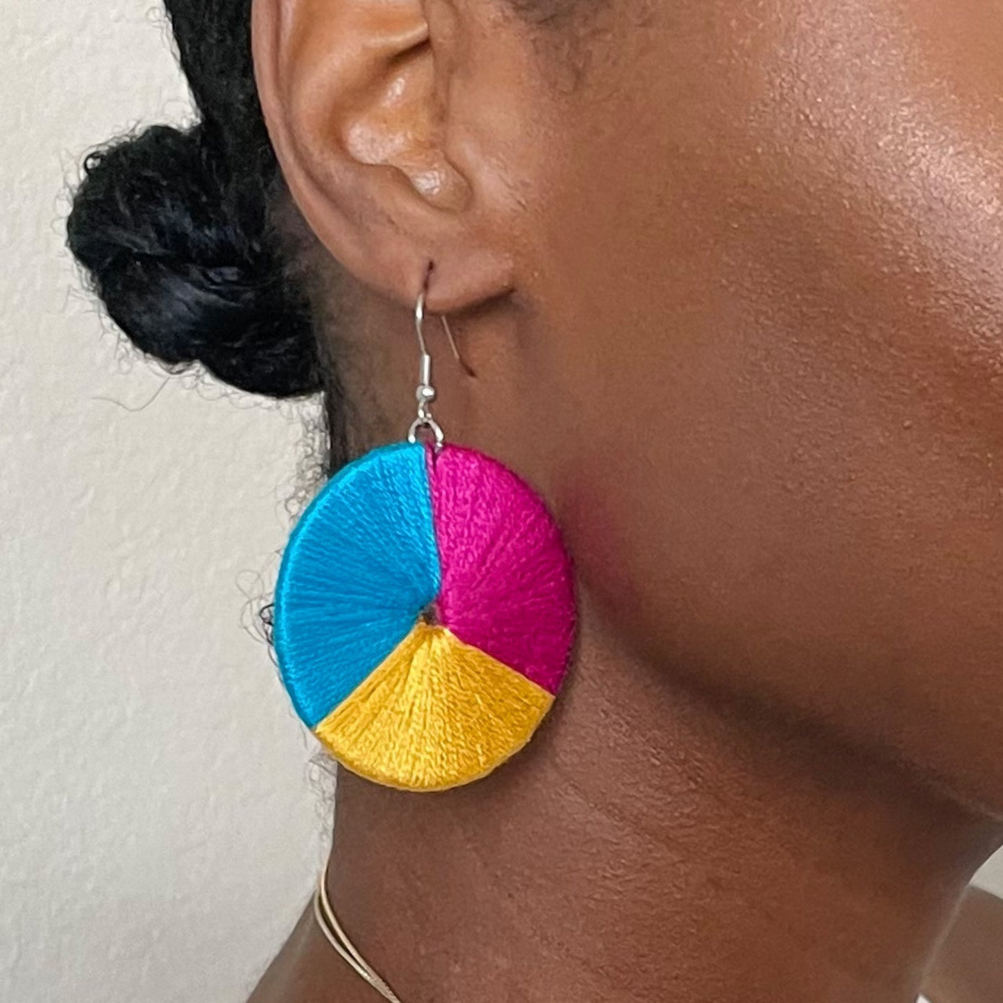 Model wearing The Bode earrings in a front-facing portrait, showcasing their statement design