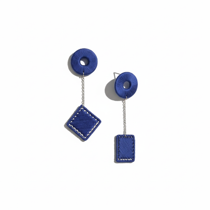 Blue earrings with circular and square designs on a white background