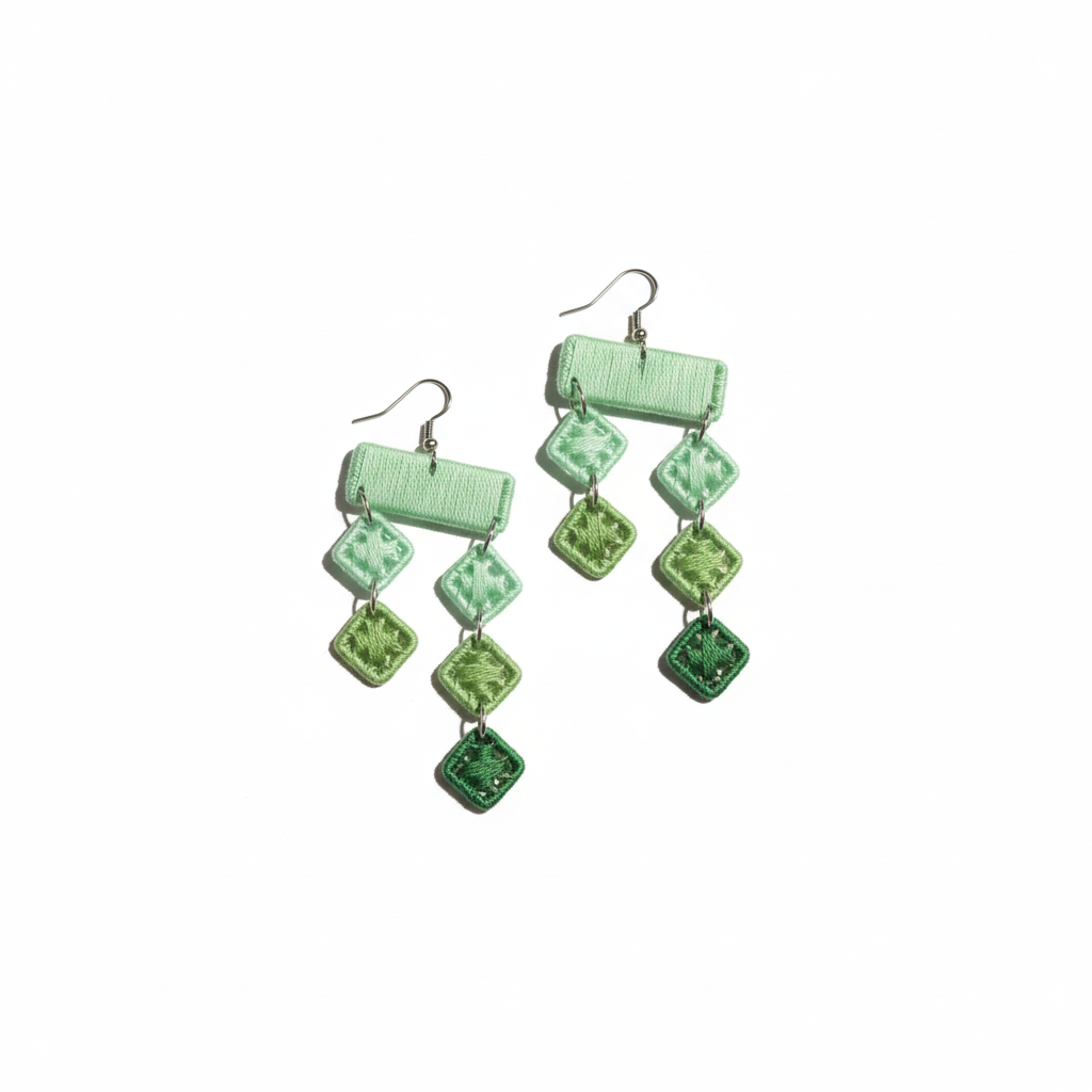 Green square patterned earrings on a white background