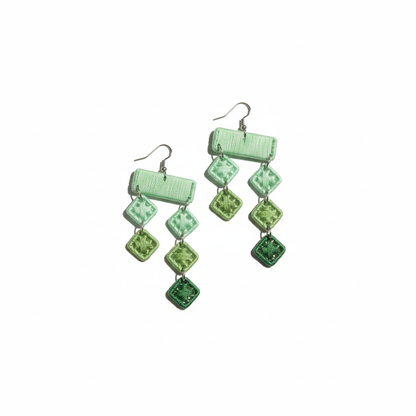 Green square patterned earrings on a white background