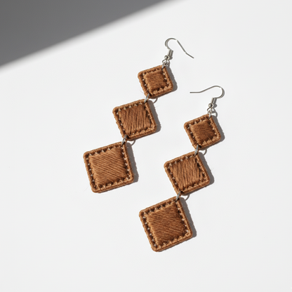 Pair of brown square earrings on a white background