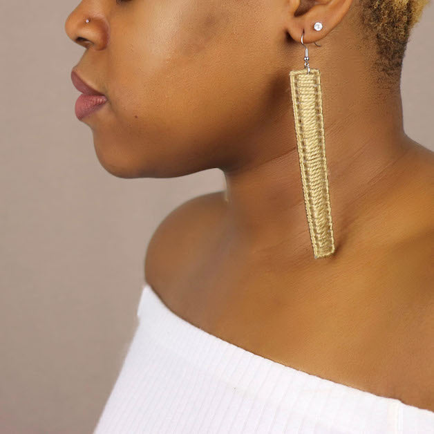 Close-up of a model wearing The Kevo earrings in gold, designed for a sleek statement look