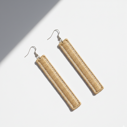 Pair of beige rectangular earrings on a light background