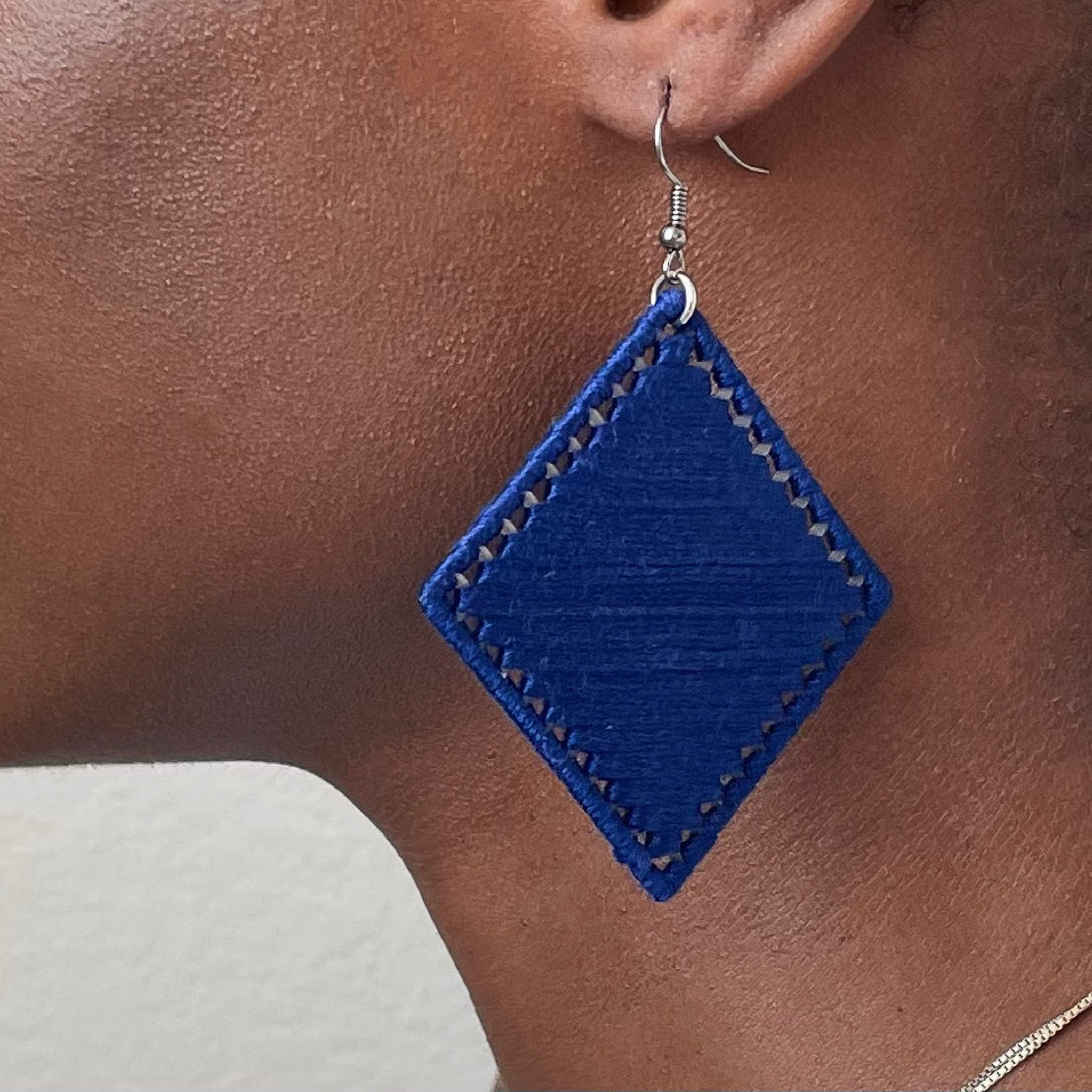 Deep blue Kwame earrings displayed elegantly, emphasizing their structured shape