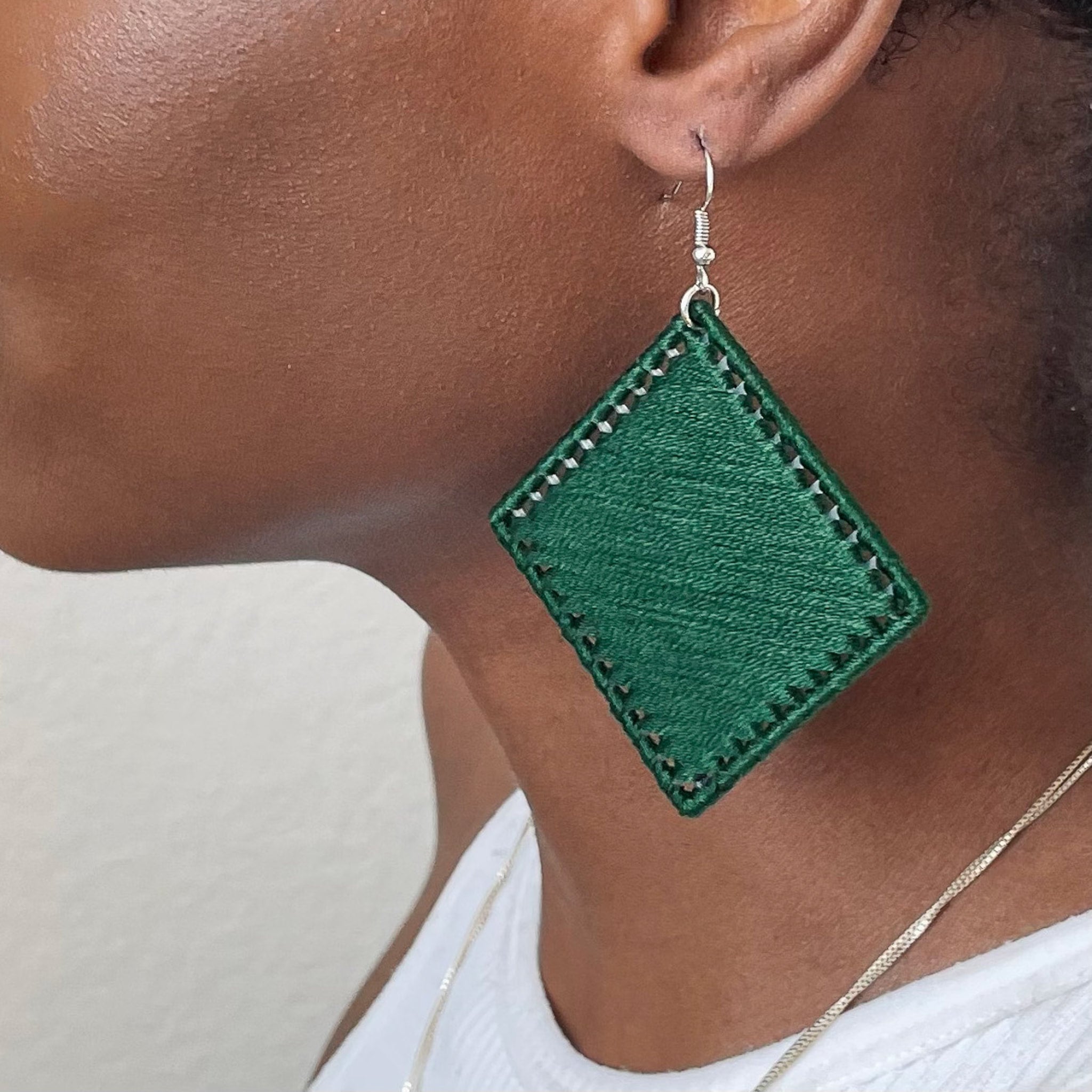 Close-up of Kwame earrings in textured green, highlighting handcrafted details