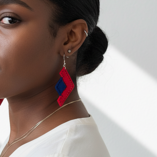 Woman wearing red and blue earrings against a white background
