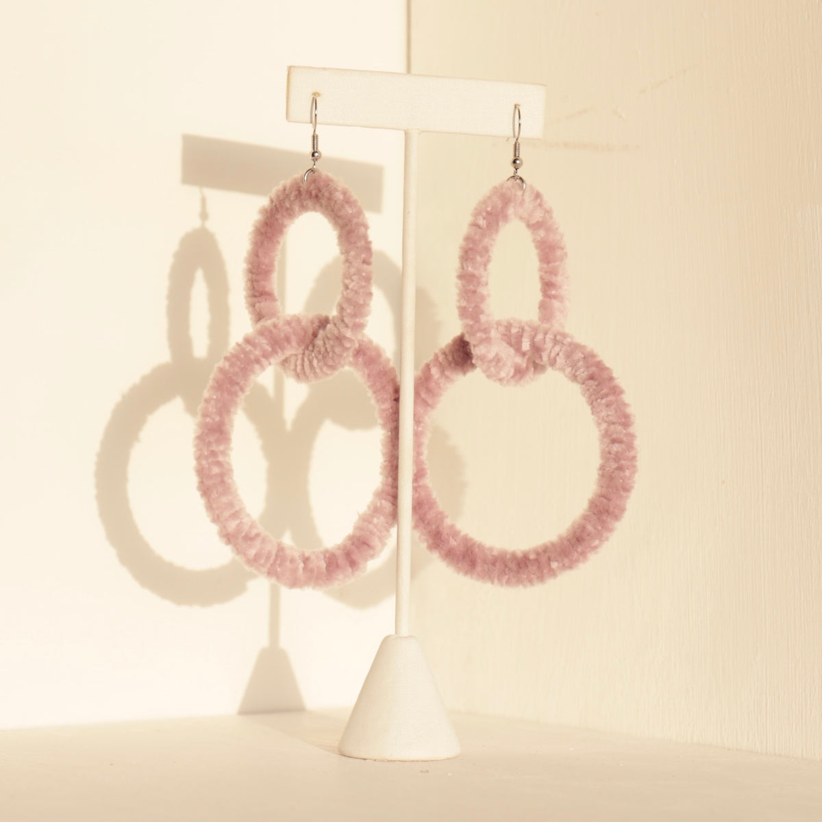 The Valente earrings in soft pink, showcasing their handcrafted texture