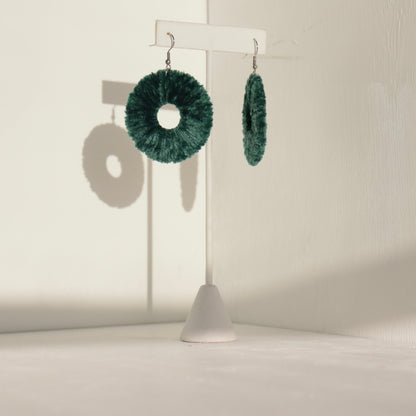 The Vinny earrings in deep forest green, capturing their lightweight yet sculptural form