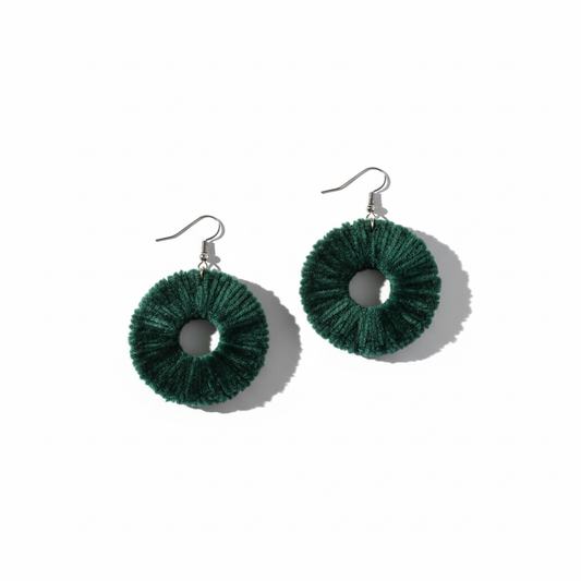 Green circular earrings on a white background